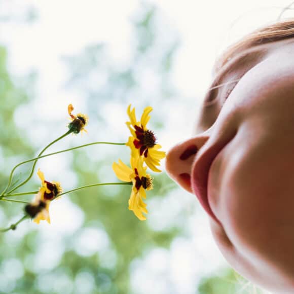 Girl smelling yellow flowers